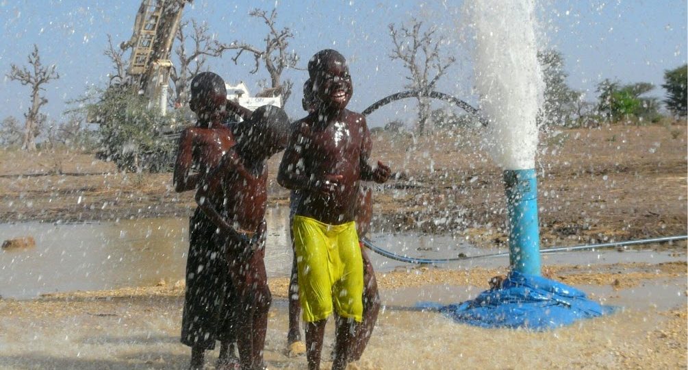 bambini festeggiano l'acqua dal pozzo